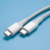 Three different USB-C cables beside a laptop and smartphone